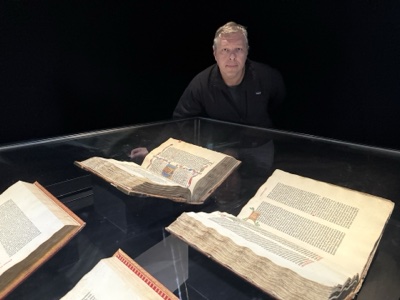 Pasha behind Gutenberg Bible display case, Frankfurt, 2026.