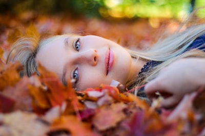 Woman lying in autumn leaves