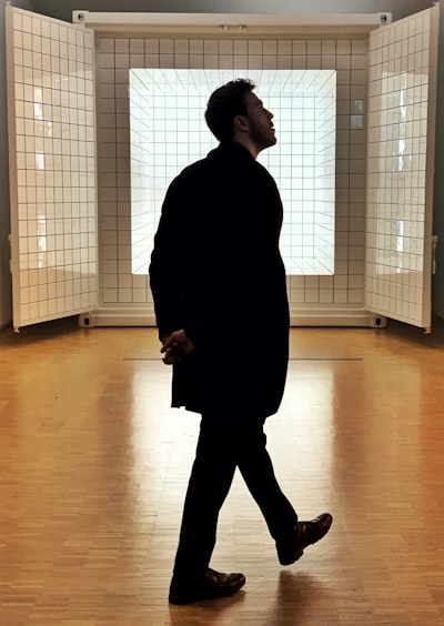 Man in black coat standing inside room