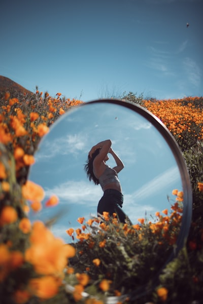 Reflective photo of woman on flower garden