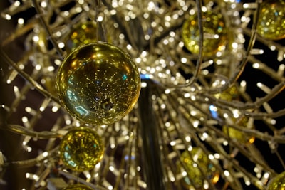 A close up of a christmas ornament with lights in the background