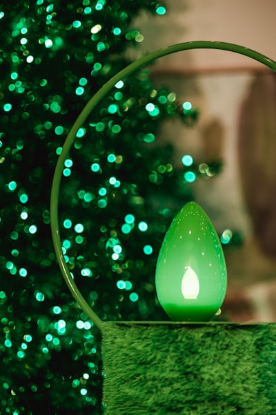 A green lighted candle sitting on top of a table