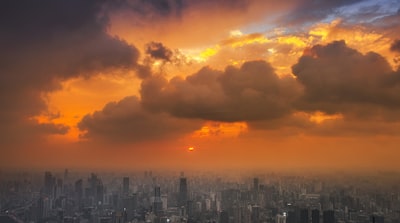 City skyline under orange and gray cloudy sky during sunset