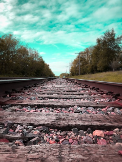 Train tracks on a sunny day with a clear sky.