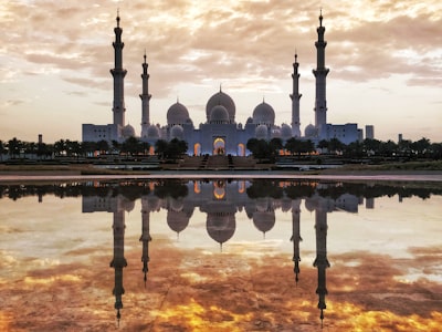 Majestic Reflections of Shaik Zayed Grand Mosque and fiery golden sky captured from the Oasis of Dignity, Abu Dhabi, UAE. 
 
 The Oasis of Dignity has still water at it's center which gives you splendid reflections of the mosque during mornings and evenings. A good place to find fellow travel & professional photographers clicking those reflections!