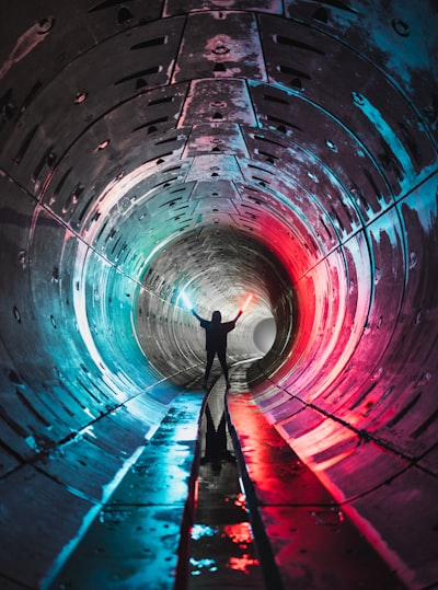 Man in blue shirt and black pants standing on tunnel