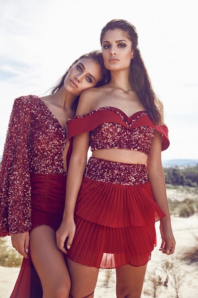 Woman leaning to woman wearing dresses