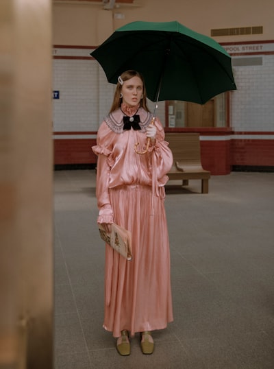 Woman in pink dress under green umbrella