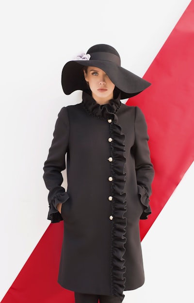 Woman wearing black long-sleeved dress and black sunhat