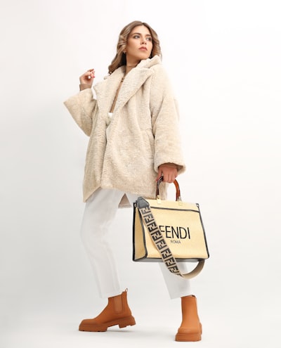A woman in a fur coat holding a fendi bag