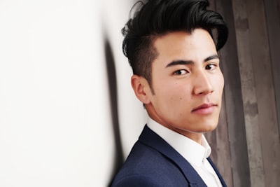 Man in blue formal suit jacket posing for picture