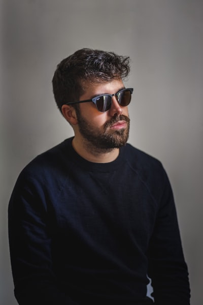 Man in black crew neck shirt wearing black sunglasses