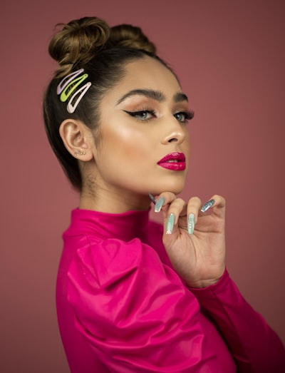 Woman wearing pink top near pink wall