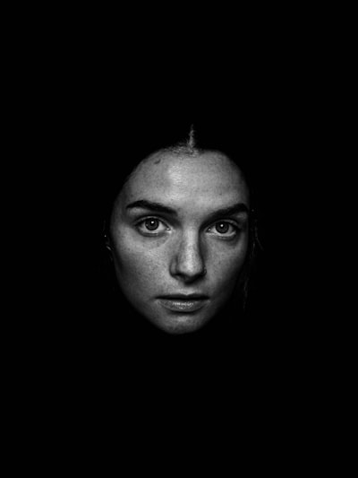 Grayscale photography of woman looking straight