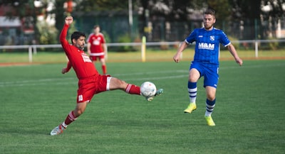 Soccer players in red and blue jersey shirt and blue shorts