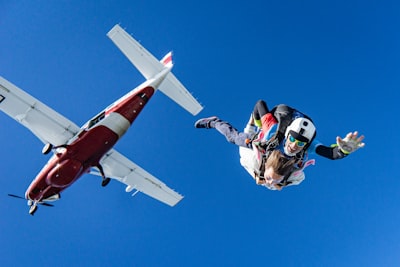 White and red airplane in mid air during daytime
