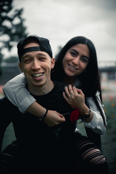Man in black long sleeve shirt smiling beside woman in white long sleeve shirt