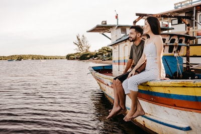 Woman in white and blue striped dress sitting on white and blue boat during daytime