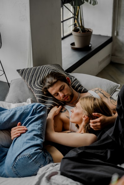 A man and a woman laying on a bed