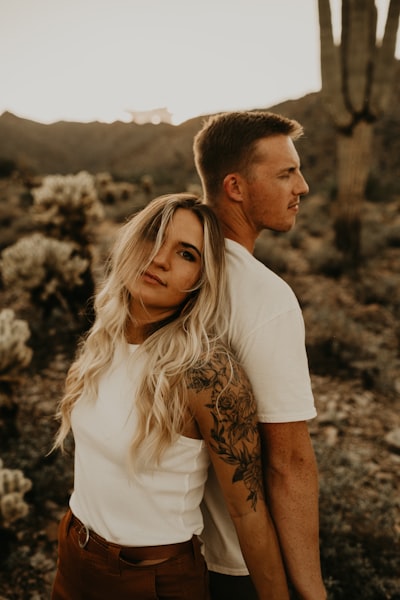 Couple embracing in desert with cacti at sunset
