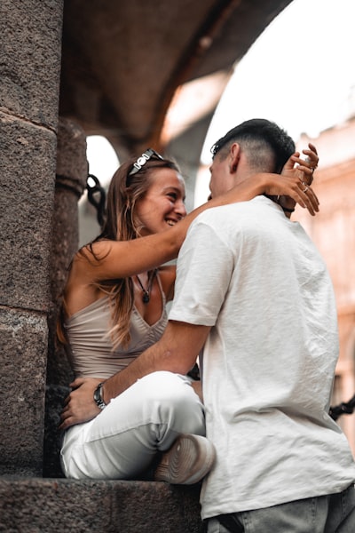 Couple laughing in embrace under stone archway