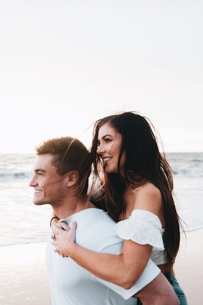 Woman in white dress kissing man in white dress shirt