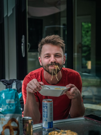 A guy eating pasta. 