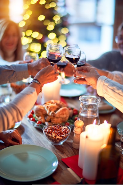 Family and friends dining at home celebrating christmas eve with traditional food and decoration, all sitting on the table together making a toast