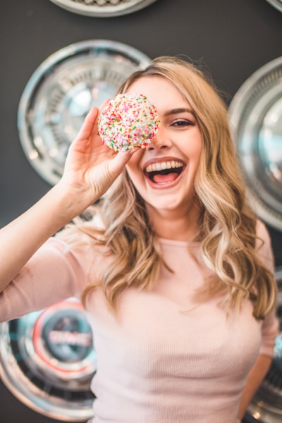 Shallow focus photography of woman holding doughnut