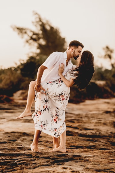 Man and woman kissing on beach during daytime
