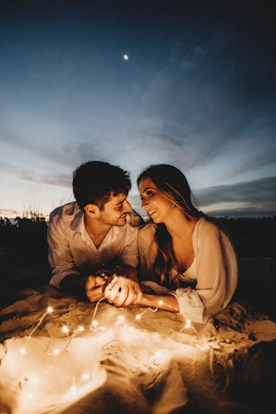 Man and woman kissing on sand during daytime
