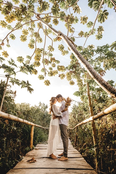 Woman in white dress standing on tree branch during daytime