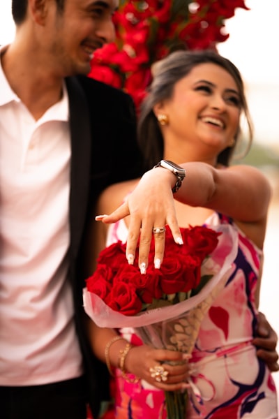 Woman showing off engagement ring with red roses
