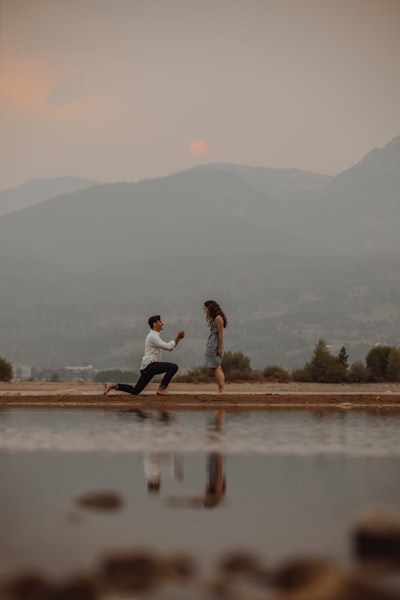 Lakeside proposal at sunset with mountain reflection