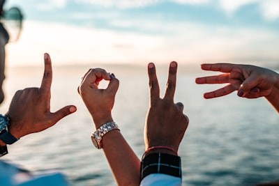 Hands spelling LOVE by the sea