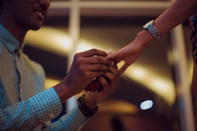 Man putting ring on woman's hand