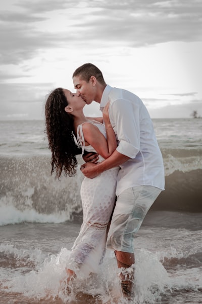 Man and woman kissing on beach during daytime
