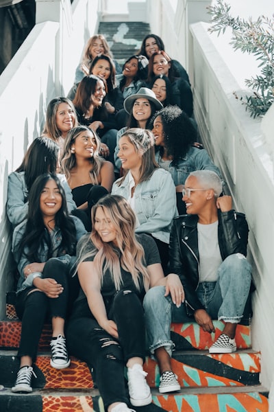 Group of people sitting on gray concrete stairs