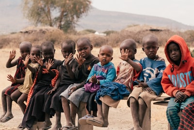 Children sitting on brown sand during daytime