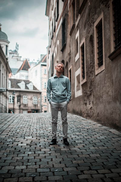 Man sitting on street near building during daytime