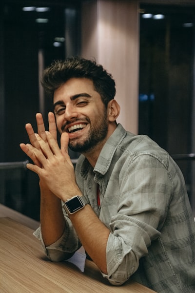 A man smiling and holding his hands up
