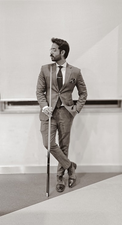 Man in brown suit holding walking stick
