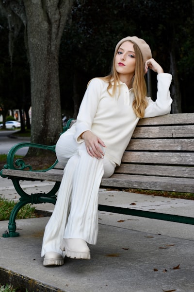 A girl on a bench in all white