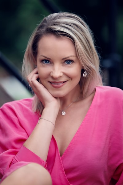 Close up portrait of a beautiful young woman dressed in a pink dress, leaning head in hand. Model Sofie (Instagram: @sofiepersson87) in Stockholm, Sweden.