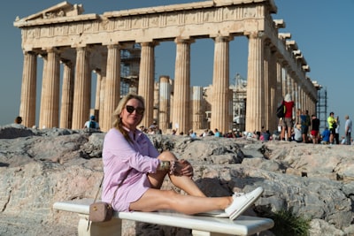 A woman leaning on a railing in front of a building