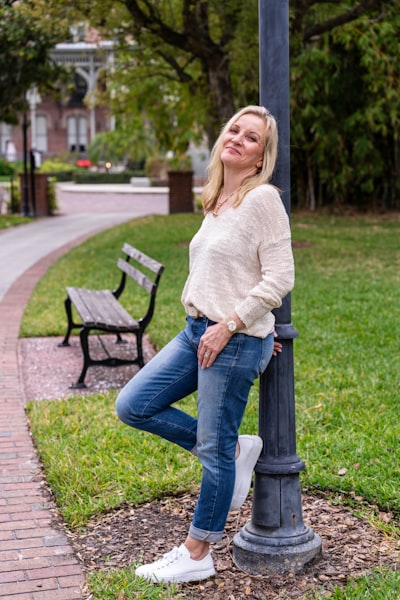 Woman leaning against lamp post in park