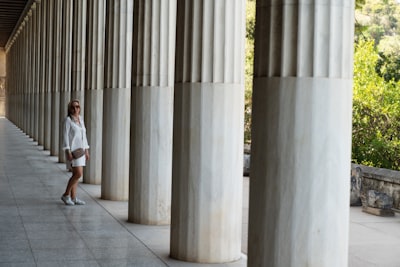 Woman standing among Greek colonnade