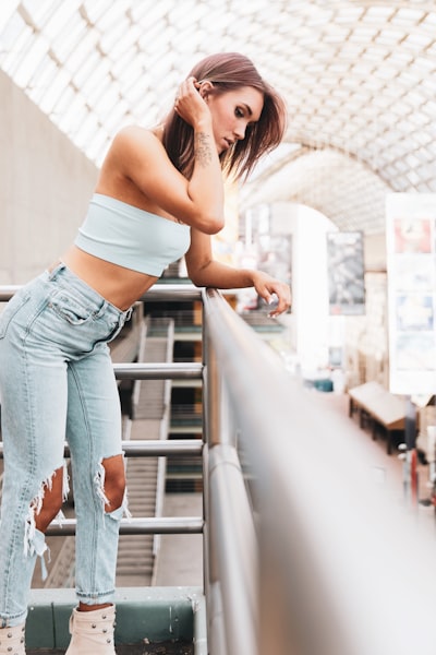 Woman leaning on railing in glass-roofed building