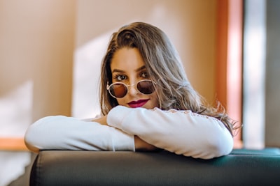 Woman with sunglasses resting chin on arms