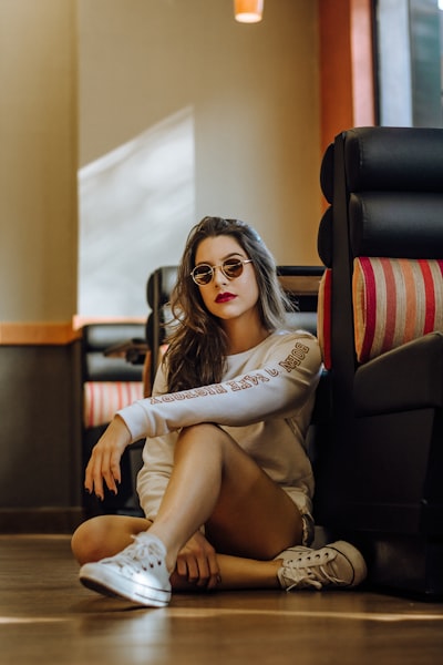 Woman in sunglasses sitting on floor by cafe seat